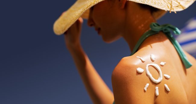 woman-tanning-at-the-beach-with-sunscreen-cream-vishca-skincare-VQB3X65 skin care